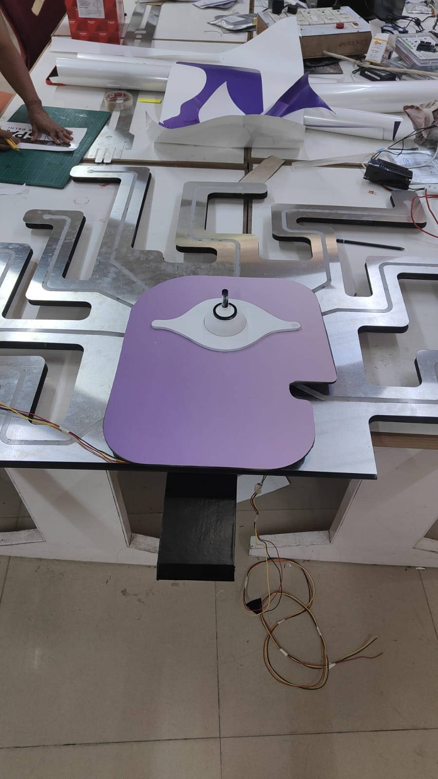 Central purple eye component being assembled over the branching metal face